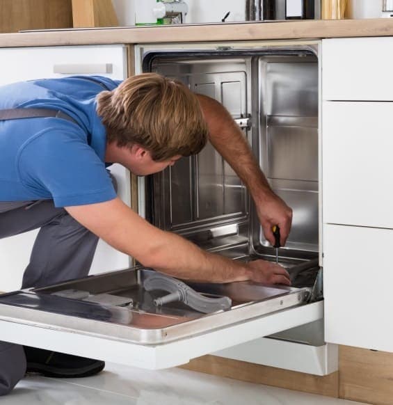 Technician repairing a built-in dishwasher